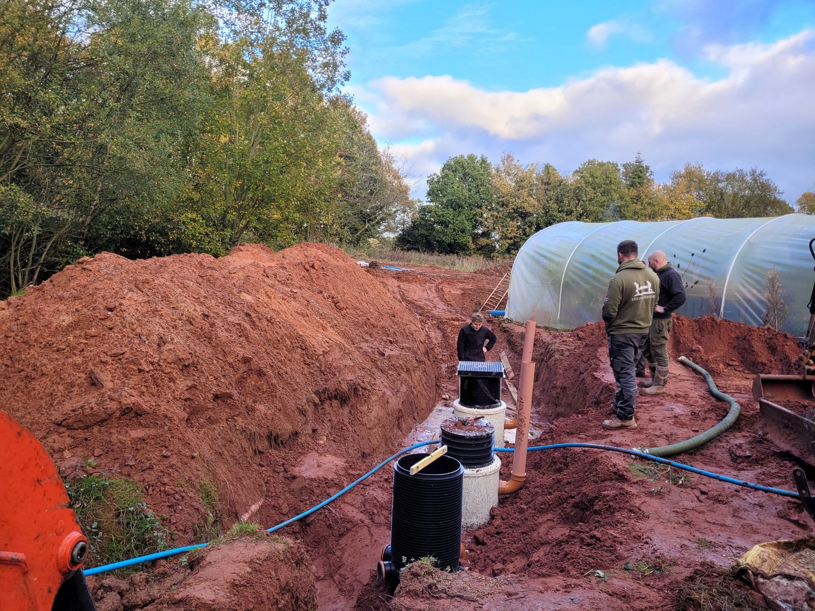 Crew installing a new septic tank in a freshly dug hole